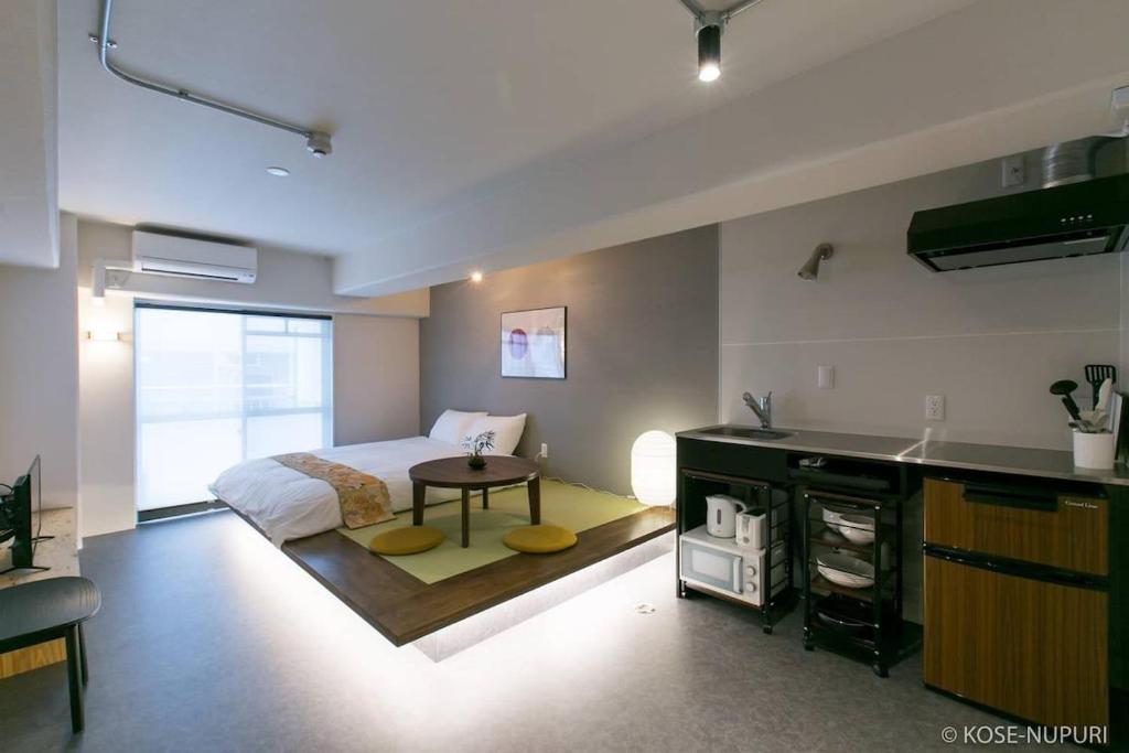 广岛bHOTEL Origaminn 503 - 5 mins PeacePark的一间卧室配有一张床,厨房配有桌子