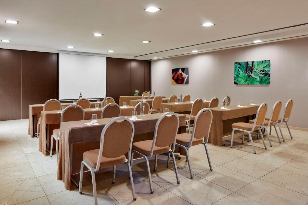 圣克鲁斯-德特内里费NH特内里费酒店的一间会议室,配有桌椅和屏幕