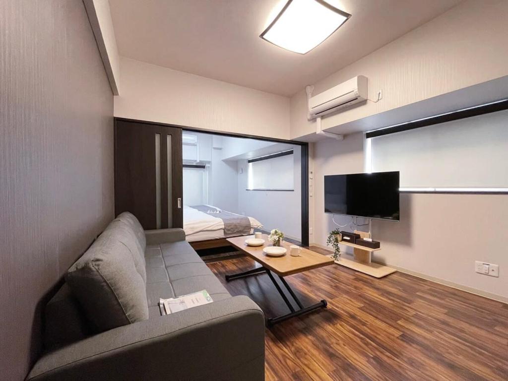 广岛bHOTEL Casaen - Brand New 1BR Apt Near Hondori Shopping District For 6 Ppl的带沙发和电视的客厅