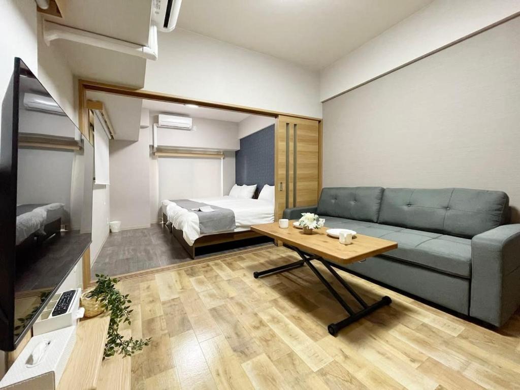 广岛bHOTEL Casaen - 1BR with balcony near Hondori Shopping Arcade, 6PPL的客厅配有沙发和1张床