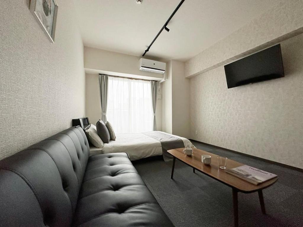 广岛bHOTEL Nagomi - Comfy Apartment for 3 people near City Center的客厅配有沙发和1张床