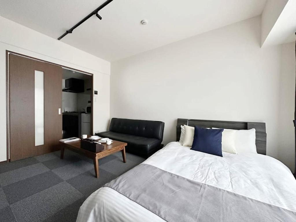 广岛bHOTEL Nagomi - Comfy 1 Bedroom in City Center for 3ppl的一间卧室配有一张床和一张沙发