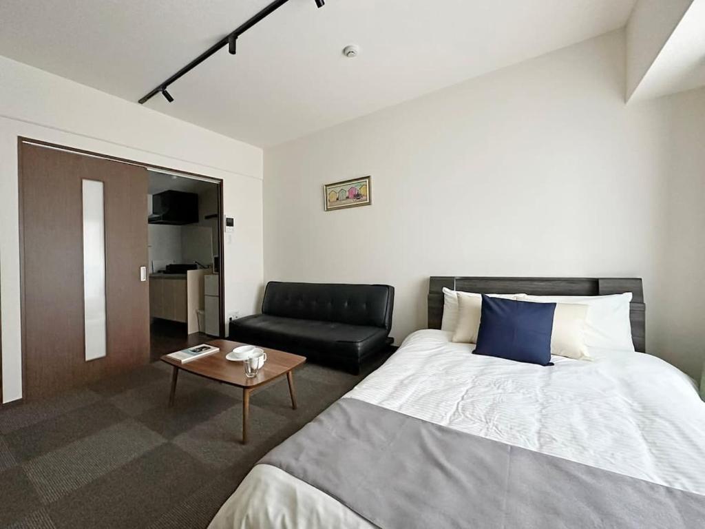 广岛bHOTEL Nagomi - Luxe Apt for 3Ppl City Center的酒店客房,配有床和沙发