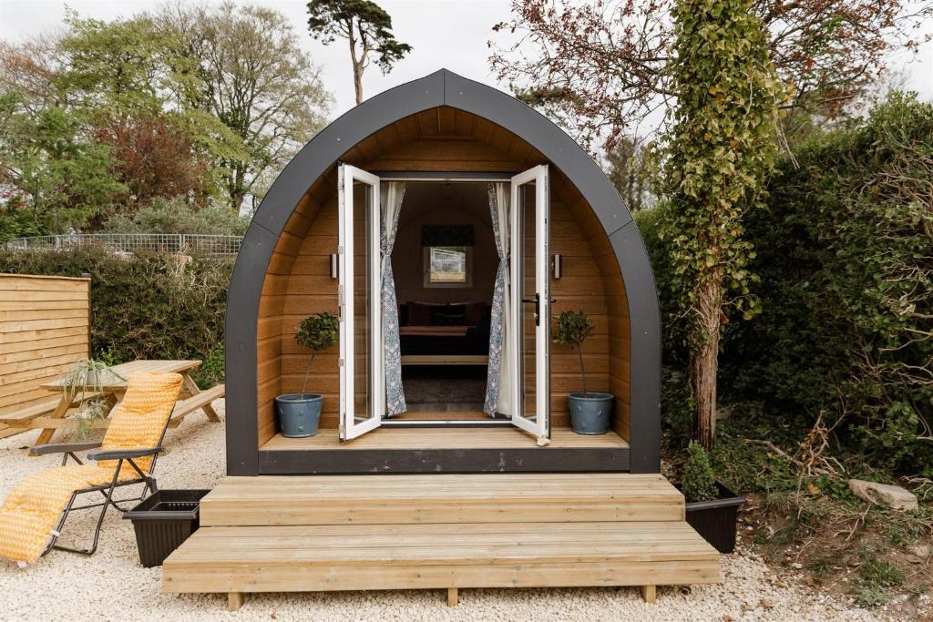 FindonThe Downs Stables Glamping Pod Theos Charm的一座带门廊的木 ⁇ 房子