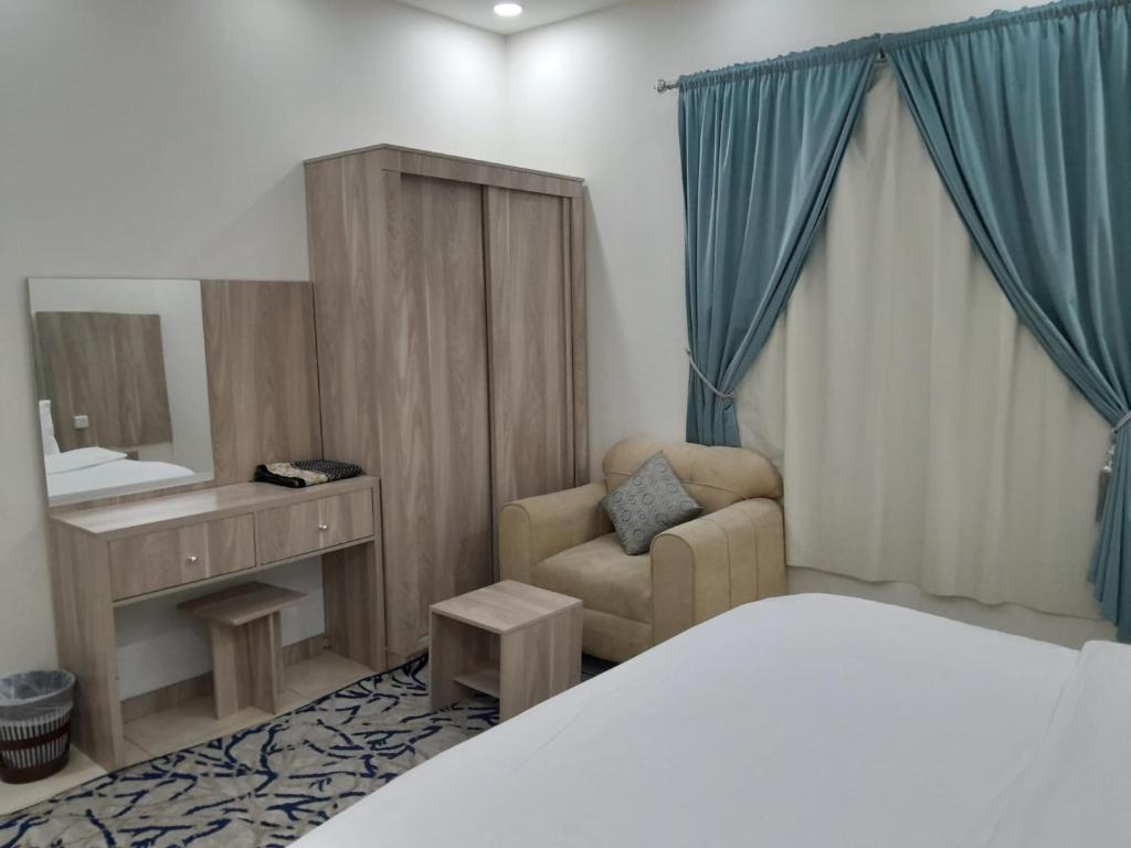 吉达دار الكيان للشقق المخدومة - Dar Al Kayan Serviced Apartments的一间卧室配有一张床、一把椅子和镜子