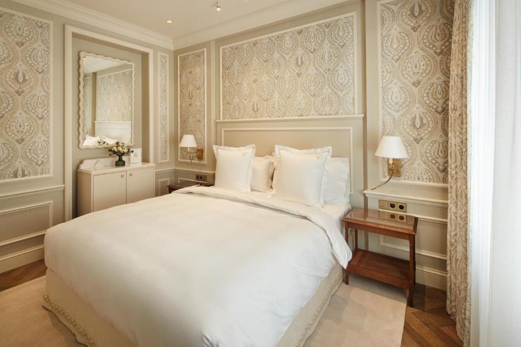 维也纳Hotel Zur Wiener Staatsoper的卧室配有一张白色大床和镜子