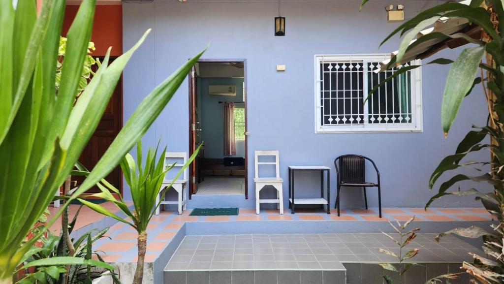 涛岛Sarin Guesthouse สาริน的庭院里带蓝色墙壁和椅子的房子