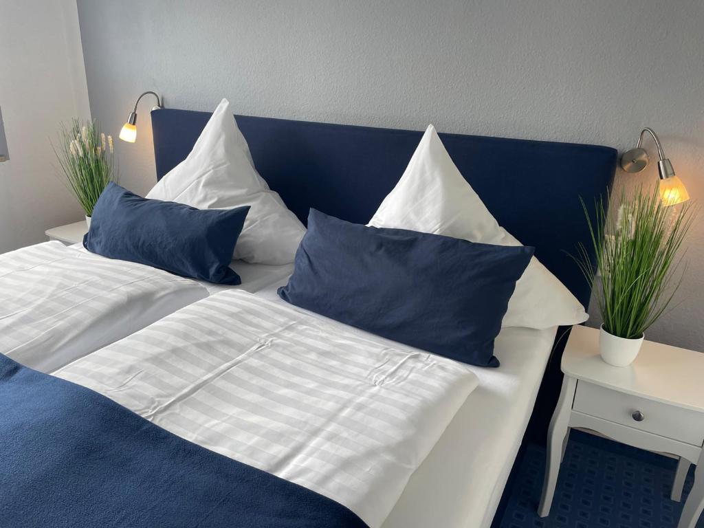 帕德博恩Hotel KAUP的蓝色和白色的床,配有蓝色和白色的枕头