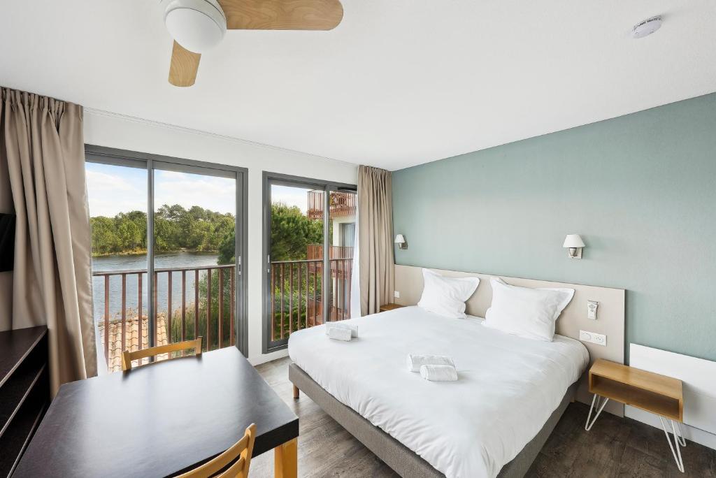 拉特斯特德布赫拉特斯特全套房酒店 - 阿卡雄湾的一间卧室配有一张床铺和一张桌子,并设有一个阳台