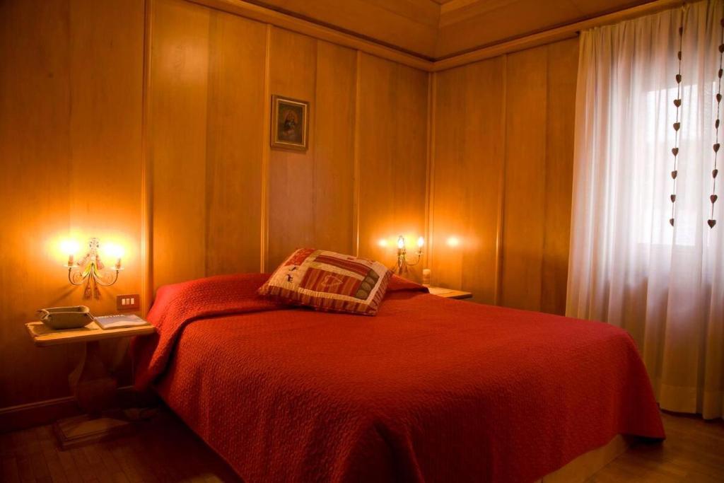 科尔蒂纳丹佩佐Casa Viola的一间卧室设有红色的床和窗户。