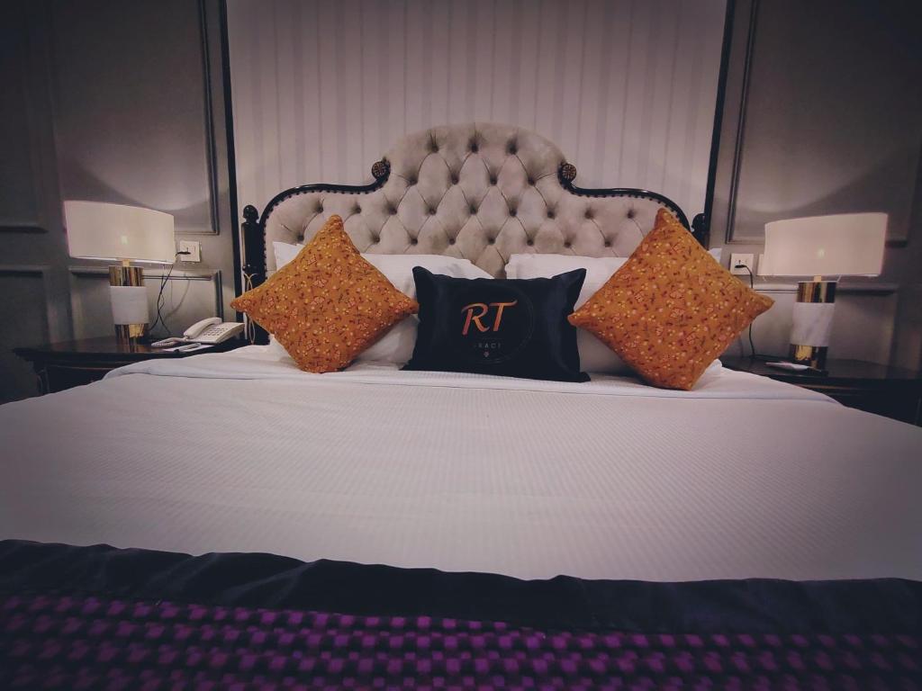 卡拉尔哥特RT Grace Royal Taj Hotel Sukkur的床上有枕头,上面有圆锥