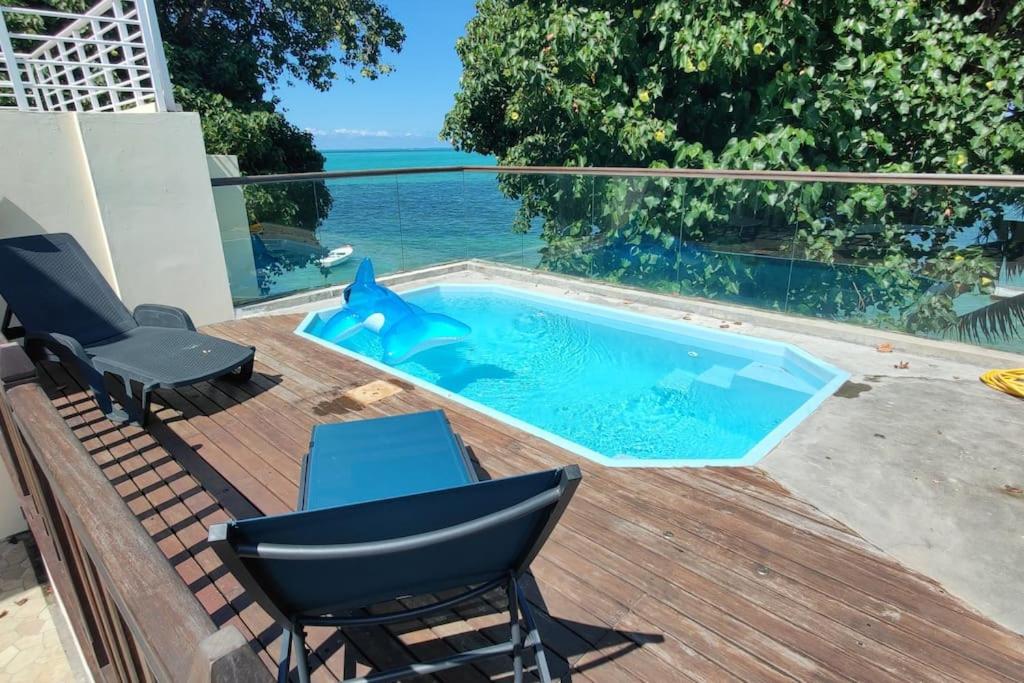 马埃堡Villa la Perle, piscine privée, vue sur le lagon的一个带椅子和桌子的甲板上的游泳池