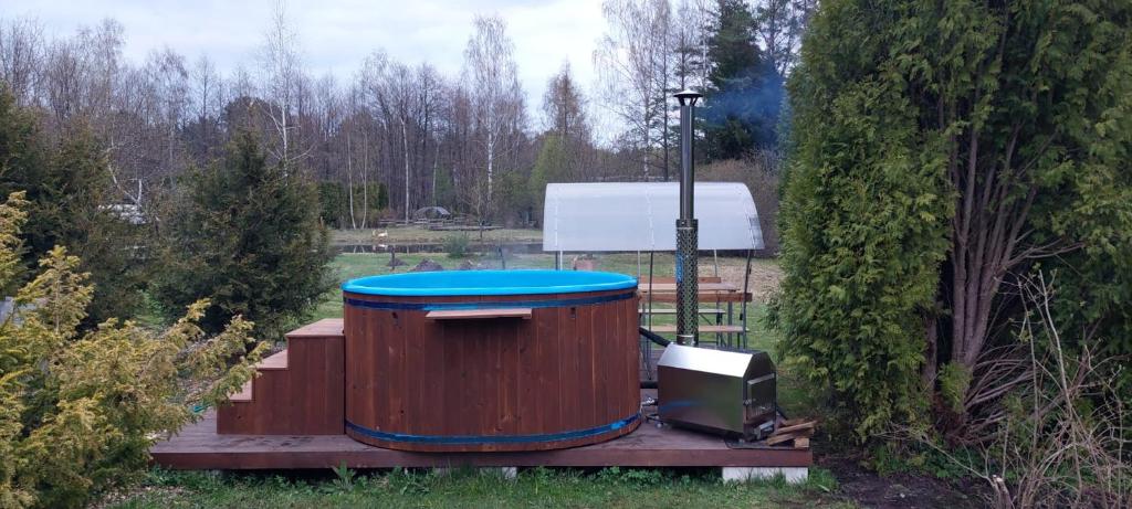 普里恩斯慕斯Hot Tub with Wigwam Fluffy Horns - Kubls ar vigvamu Pūkainie Ragi的木桶,木甲板上有一个蓝色的盖子