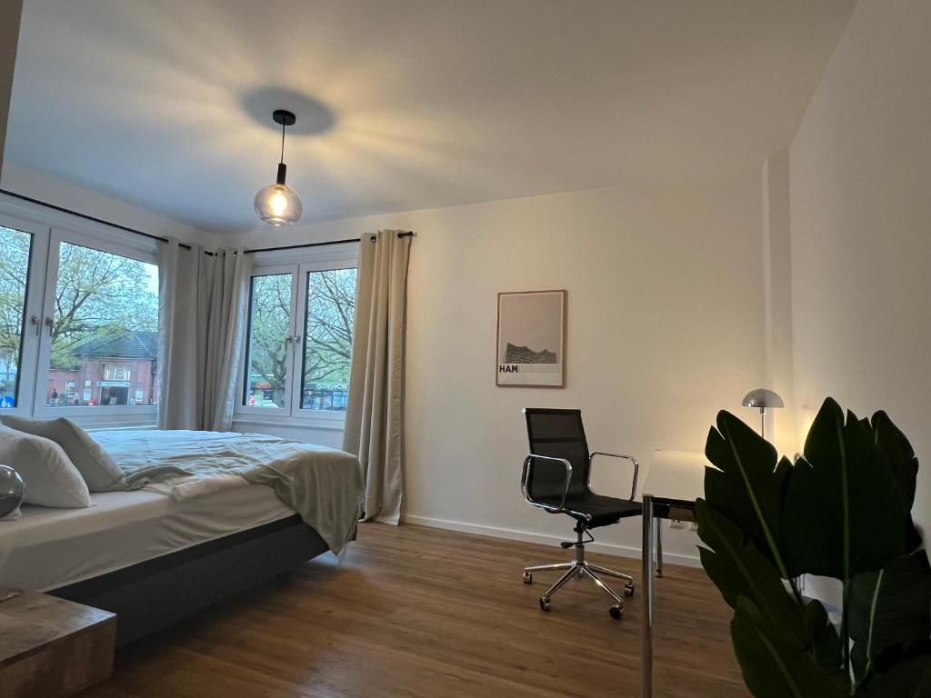 汉堡Business Apartment Kranich: 3 Zimmer, Top Infrastrukturlage HH Langenhorn, Nähe Airport的一间卧室配有一张床、一张桌子和一把椅子