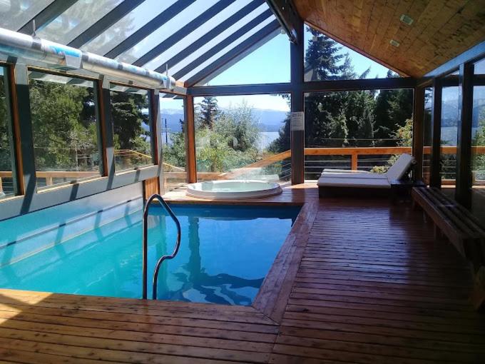 圣卡洛斯-德巴里洛切Alojamiento en Aldea Andina的一座带木甲板的别墅内的游泳池