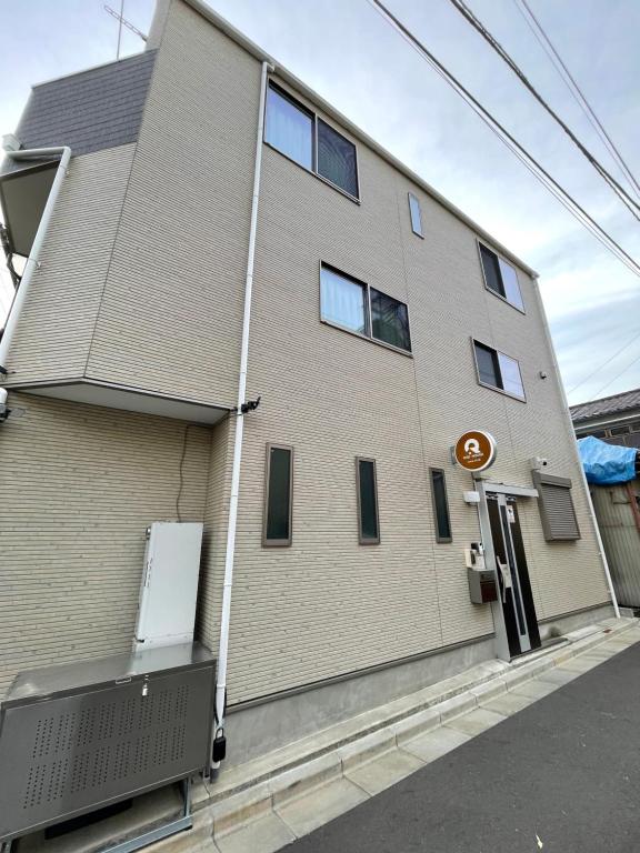 东京QiQi House Serenity 新築一軒家宿 Brand New Exclusive 3-Story House Near Tokyo Skytree Asakusa的砖砌的建筑,旁边标有标志