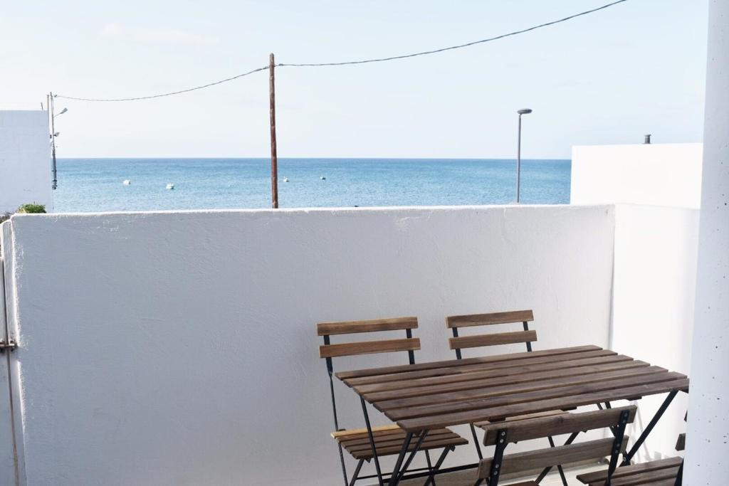LajitaLa Lajita Barca Beach的阳台上配有两把椅子和一张木桌,享有海景