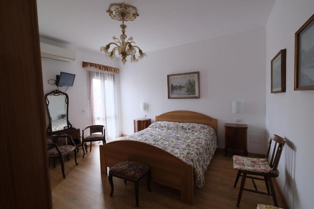 布拉诺岛Casa degli Artisti的卧室配有一张床和一张桌子及椅子