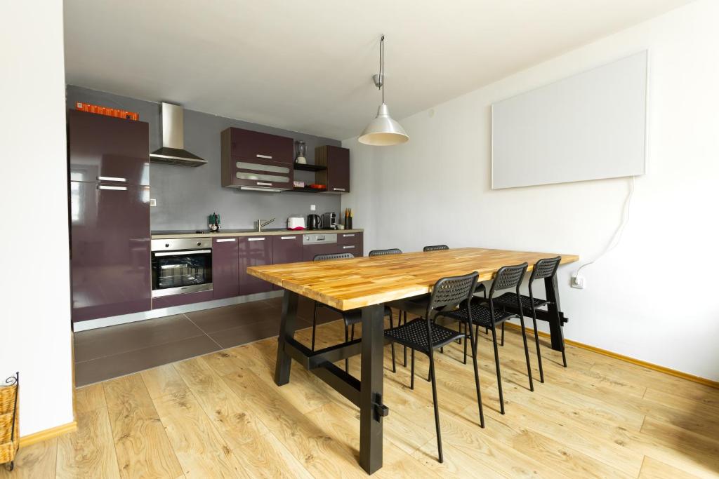 博维茨Svarun apartment的厨房配有木桌和黑色椅子