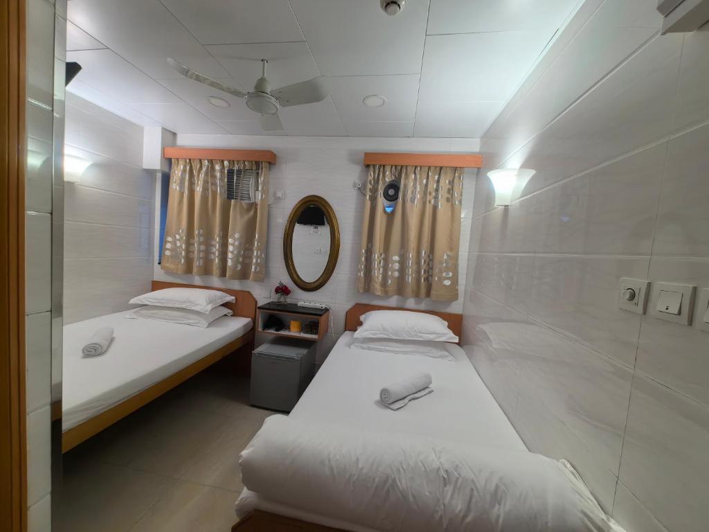 香港景士迪宾馆的小型客房的两张床,配有镜子