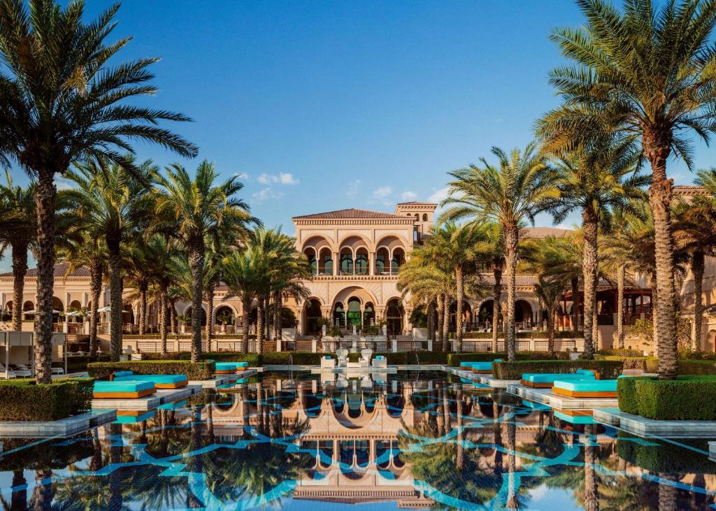 迪拜迪拜奥尼乐帕姆酒店的一座棕榈树度假村,位于一座建筑前