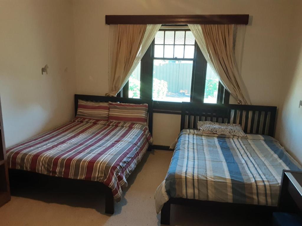 阿德莱德Peaceful Haven的一间卧室设有两张床和窗户。