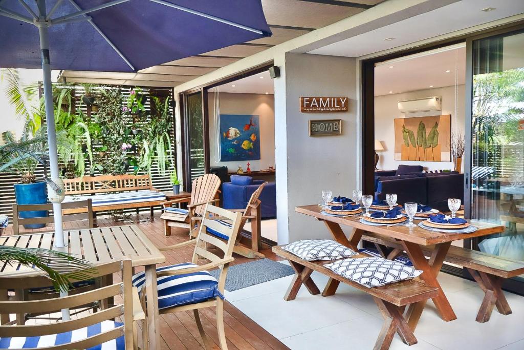 朱奎Condomínio Quinta de Juquehy - Prime Experience的用餐室配有桌椅和遮阳伞
