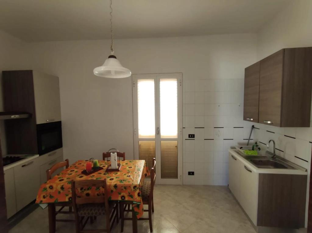 法萨诺3 bedrooms apartement with garden and wifi at Stazione di Fasano 8 km away from the beach的一间带桌子和椅子的厨房和一间带桌子的厨房