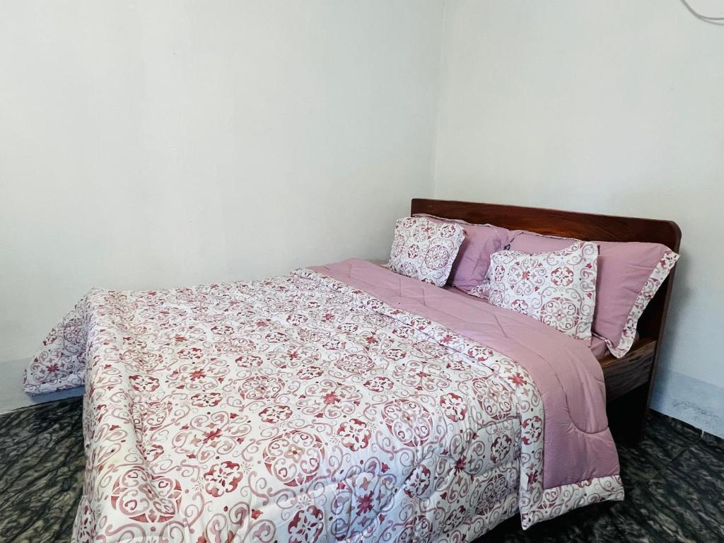 朱巴Home Stays Juba的一张带粉色和白色床单及枕头的床