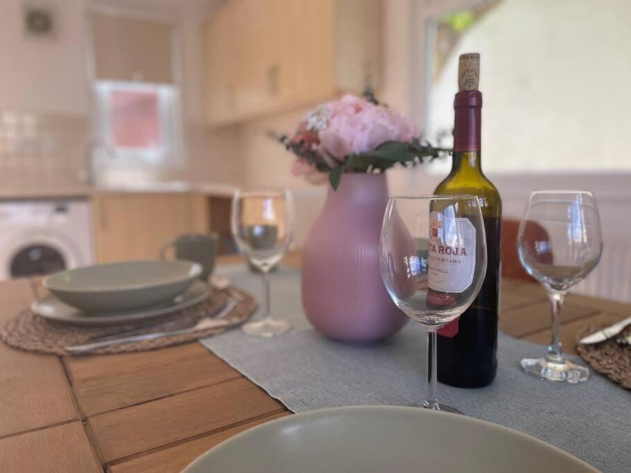 霍尔斯特德Charming 3-Bed Home in Halsted的一张桌子,上面放着一瓶葡萄酒和两杯酒杯