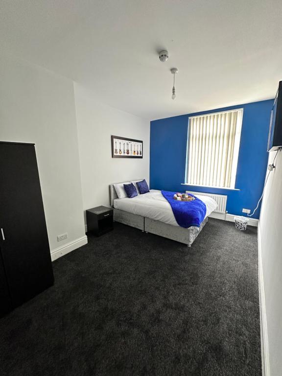 利物浦Quirky Oasis Queens的一间卧室设有一张床和蓝色的墙壁
