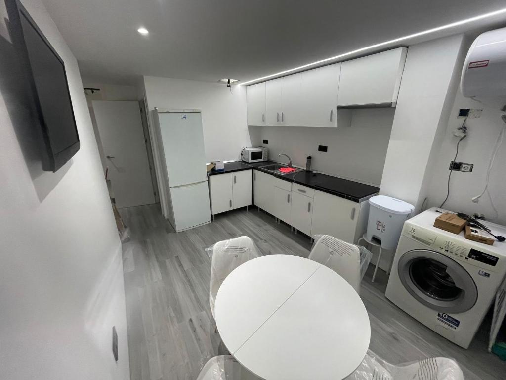 格拉纳达Inverpol的小厨房配有白色的桌子和洗衣机。