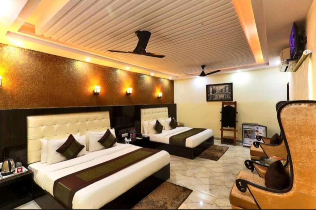 新德里HOTEL AIRPORT INN near Delhi Airport的酒店客房,设有两张床和一张沙发