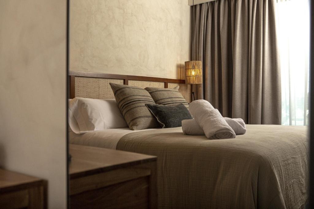 贝尼卡西姆Albades Hotel & Spa - Adults Only的卧室配有带枕头的床铺和窗户。