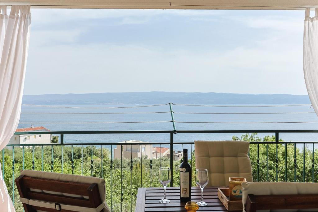 耶塞尼采STAR of the SEA的阳台配有桌子和酒杯,享有风景。