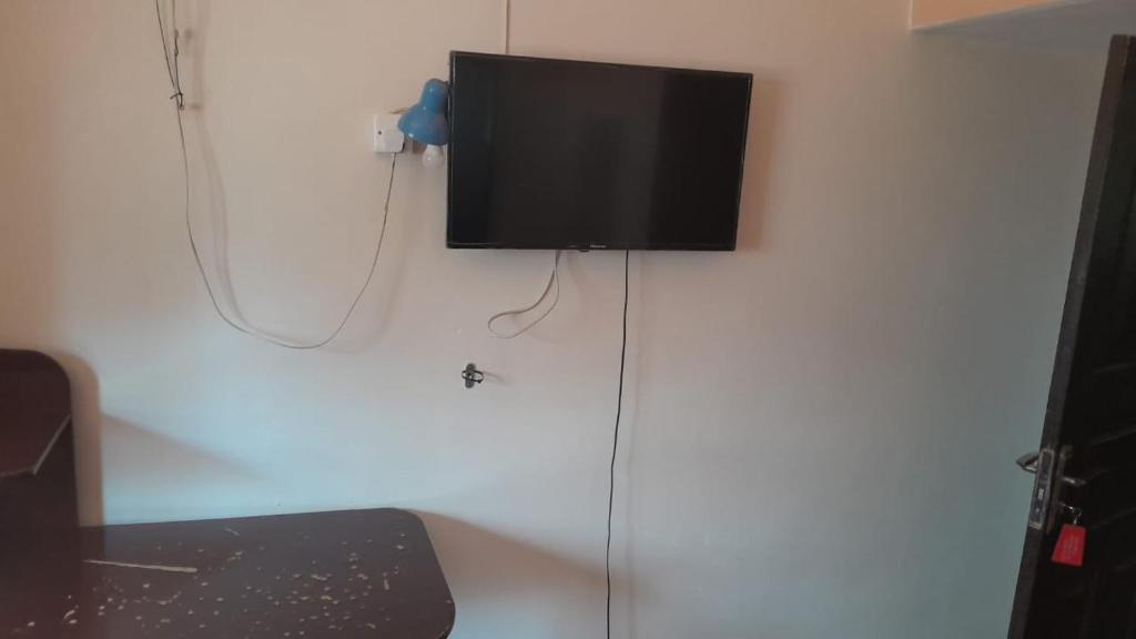 金贾Meral inn Jinja的挂在墙上的平面电视