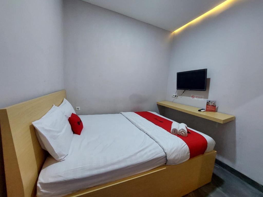 SibengkokGuesthouse Cempaka的一间小卧室,配有一张床和电视