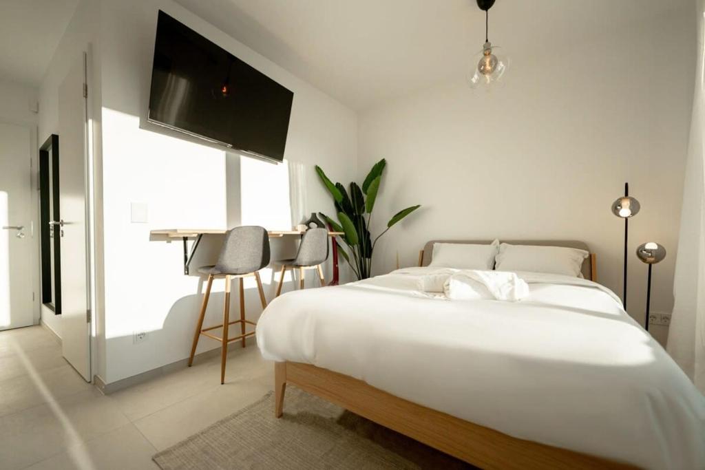 卢森堡Prime Location Modern Gem in Gasperich的白色卧室配有一张大床和一张桌子
