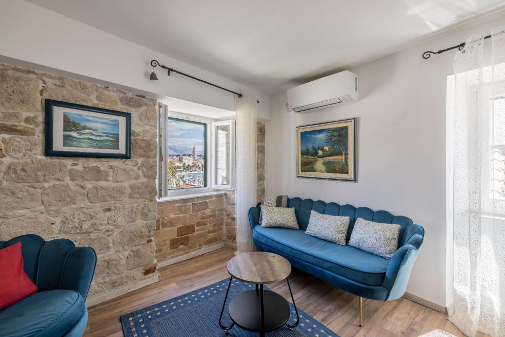 斯普利特里瓦长廊度假屋的客厅设有蓝色的沙发和砖墙