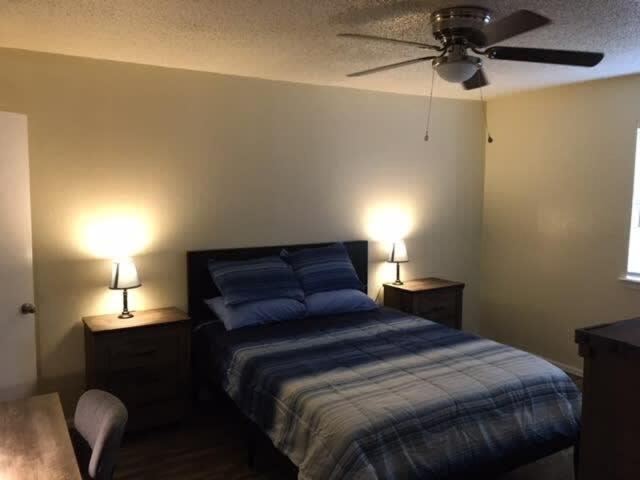 劳顿Simple 1-bedroom unit upstairs close to Fort Sill!的一间卧室配有一张带2个床头柜和2盏灯的床。