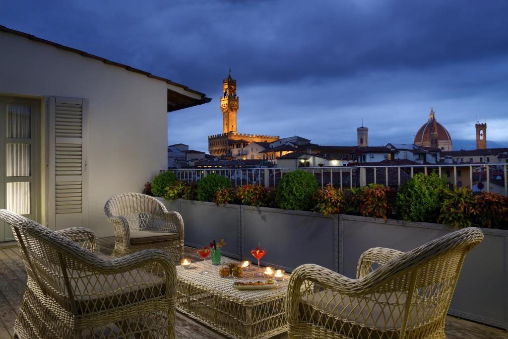 佛罗伦萨Hotel Balestri - WTB Hotels的天井配有两把椅子和一张带蜡烛的桌子。