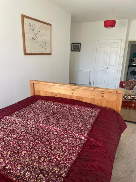 格拉斯哥Homestay的一间卧室配有一张床铺,床上铺有红色毯子