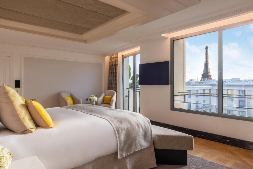 巴黎Hotel du Collectionneur的一间卧室设有一张大床,享有艾菲尔铁塔的景色