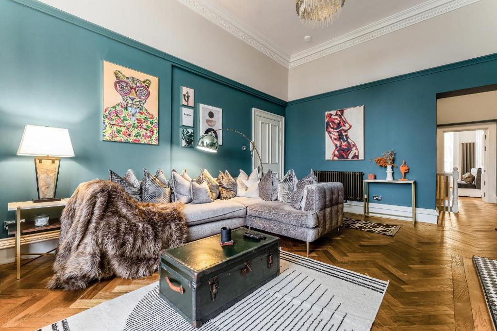 格拉斯哥Luxurious Park District Duplex Apartment的客厅拥有蓝色的墙壁和沙发