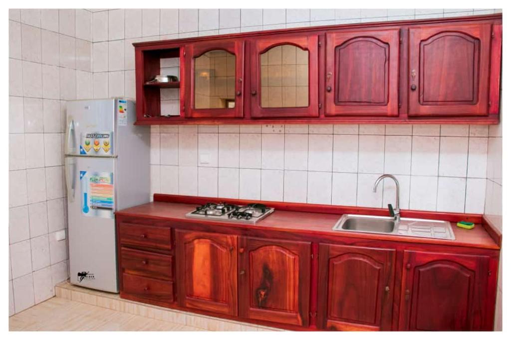 BafoussamRésidences K and D的厨房配有红色橱柜和白色冰箱