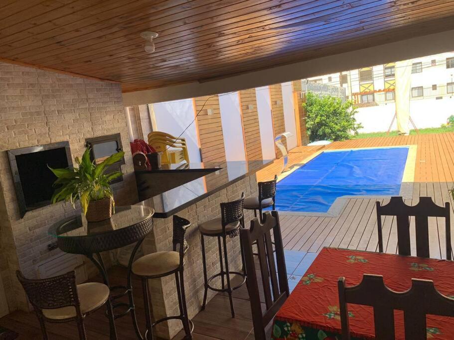卡斯卡韦尔Casa com Piscina em Região Nobre de Cascavel的厨房设有配备椅子的酒吧和游泳池