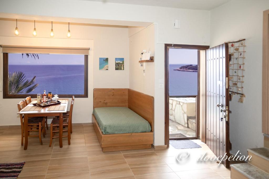 阿吉奥斯伊欧尼斯Uranus Blue Residence Agios Ioannis Papa Nero的客房设有一张床铺和一张桌子,享有海景。