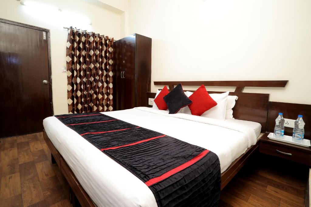 瓜廖尔TRP VIVEK CONTINENTAL的一间卧室配有一张大床,提供红色和黑色的枕头