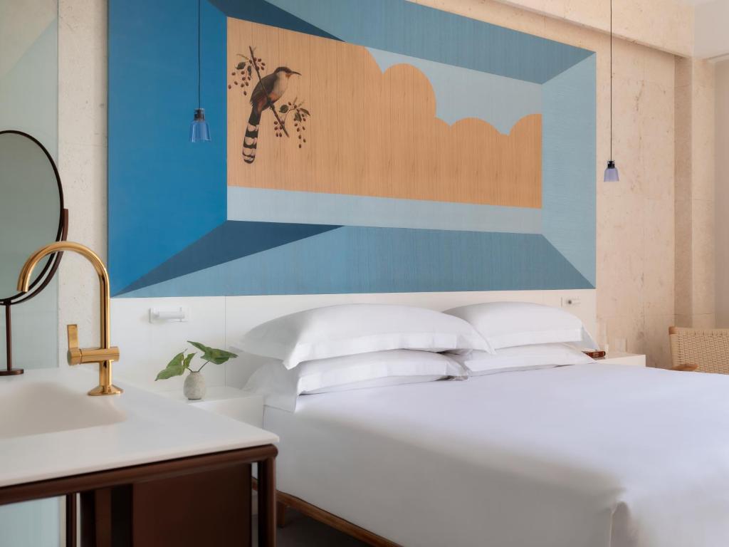 圣多明各Kimpton Las Mercedes, an IHG Hotel的一间卧室配有一张壁画大床