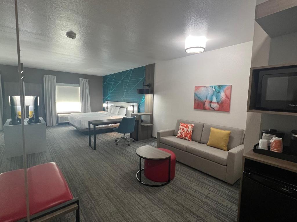 迪索托Comfort Suites DeSoto Dallas South的酒店客房设有一张沙发和一张床